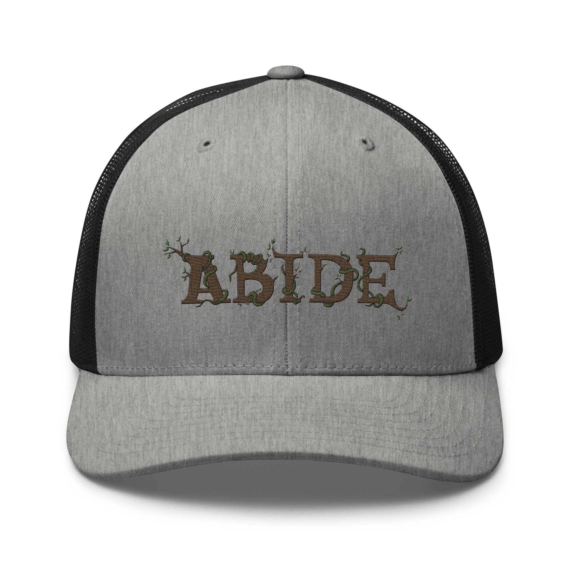 Grey trucker hat with black mesh with the letters Abide on the front. The letters are in brown with green vines wrapped around. The Abide is embroidered on the hat.