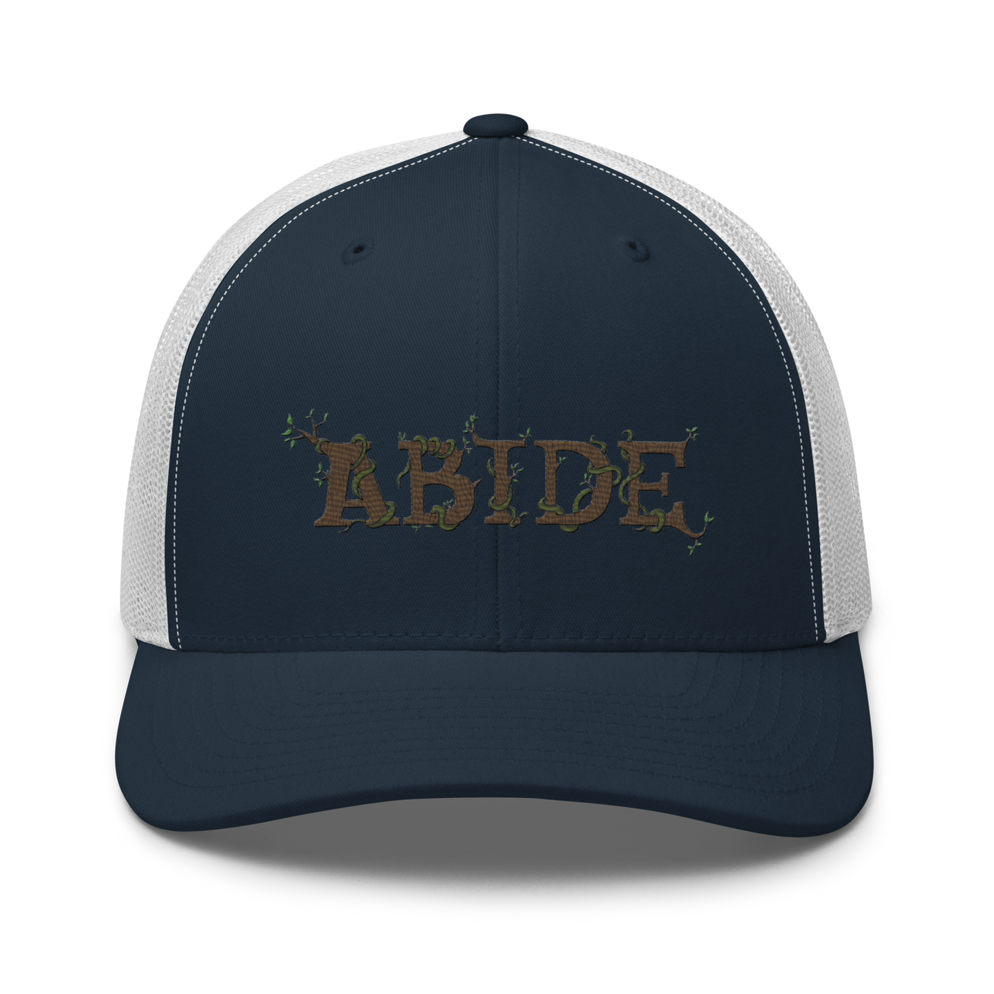 Navy blue trucker hat with white mesh with the letters Abide on the front. The letters are in brown with green vines wrapped around. The Abide is embroidered on the hat.