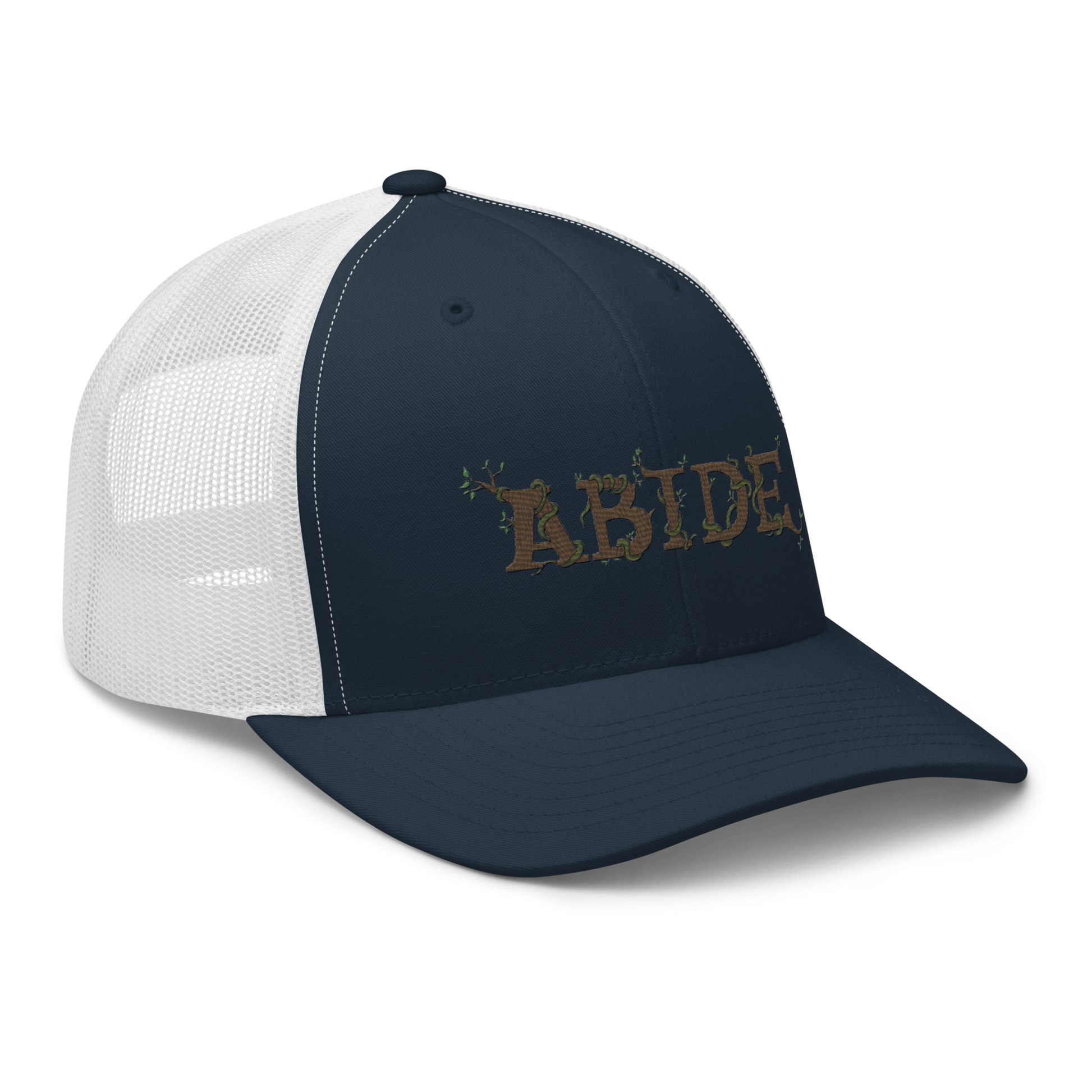 Navy blue trucker hat with white mesh with the letters Abide on the front. The letters are in brown with green vines wrapped around. The Abide is embroidered on the hat.