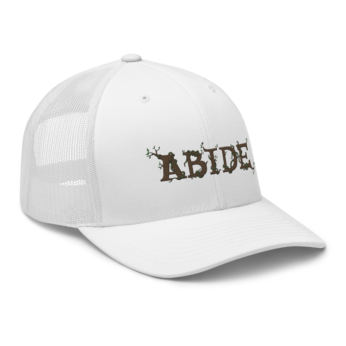 White trucker hat with the letters Abide on the front. The letters are in brown with green vines wrapped around. The Abide is embroidered on the hat.